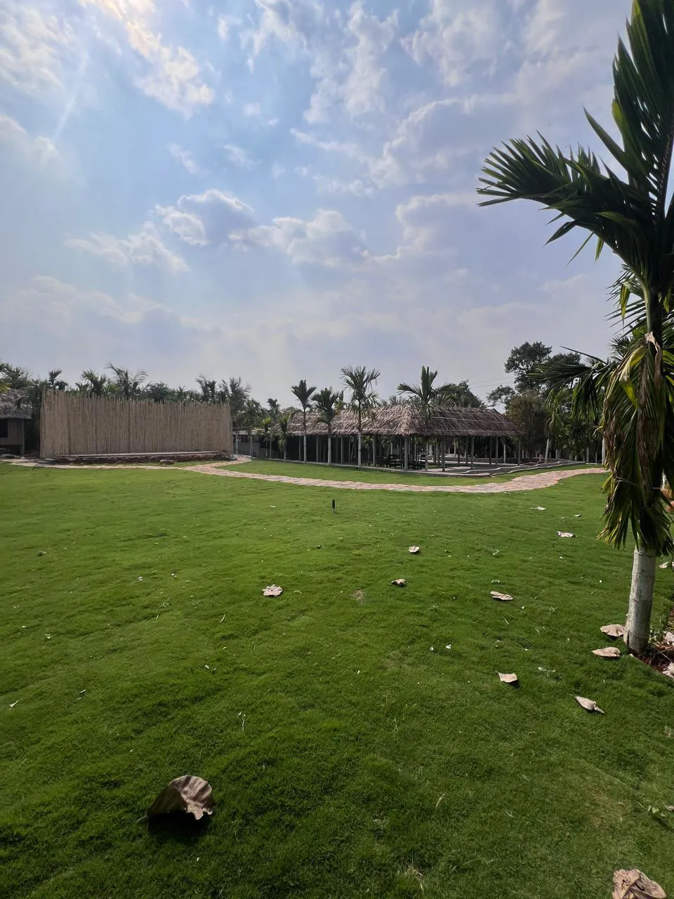 Open lawn with the thatched pavilion in the distance